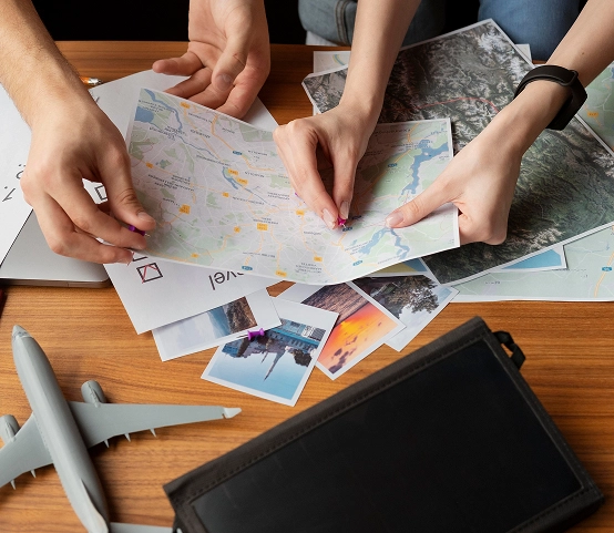 A Group Of People Examining Maps While A Plane Is Visible In The Background
